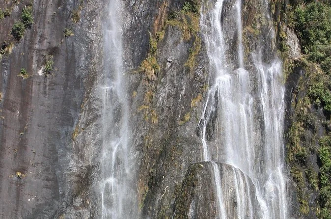 Cascadas de agua que bajan por una pared de roca oscura en el valle del glaciar